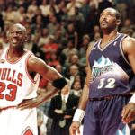 Michael Jordan (L) sonríe durante un tiro libre junto a Karl Malone (R) en las Finales de la NBA en 1998.