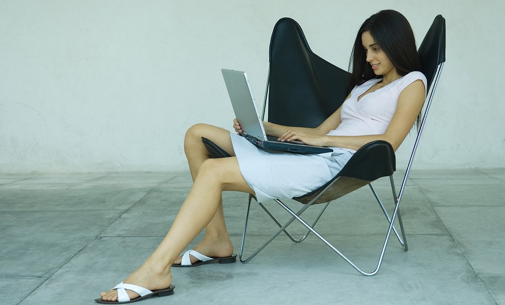 Chica sentada con computadora en su regazo