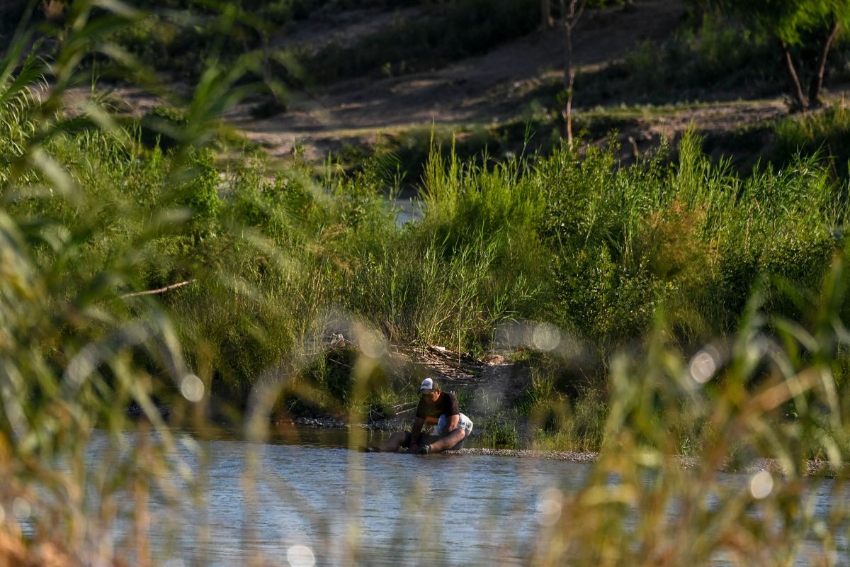 Una migrante en la orilla del Río Grande en Eagle Pass, Texas.