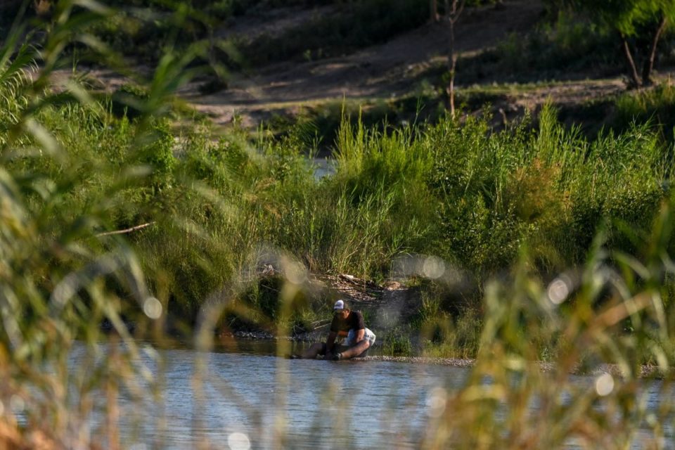 Una migrante en la orilla del Río Grande en Eagle Pass, Texas.