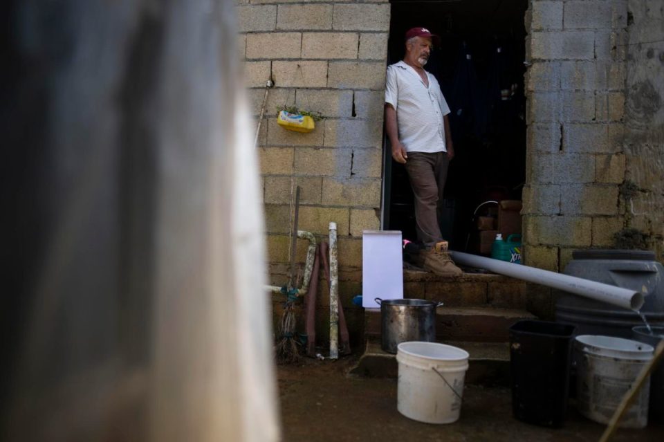 Manuel López Colón,  recoge agua de un riachuelo para lavar a mano la ropa.