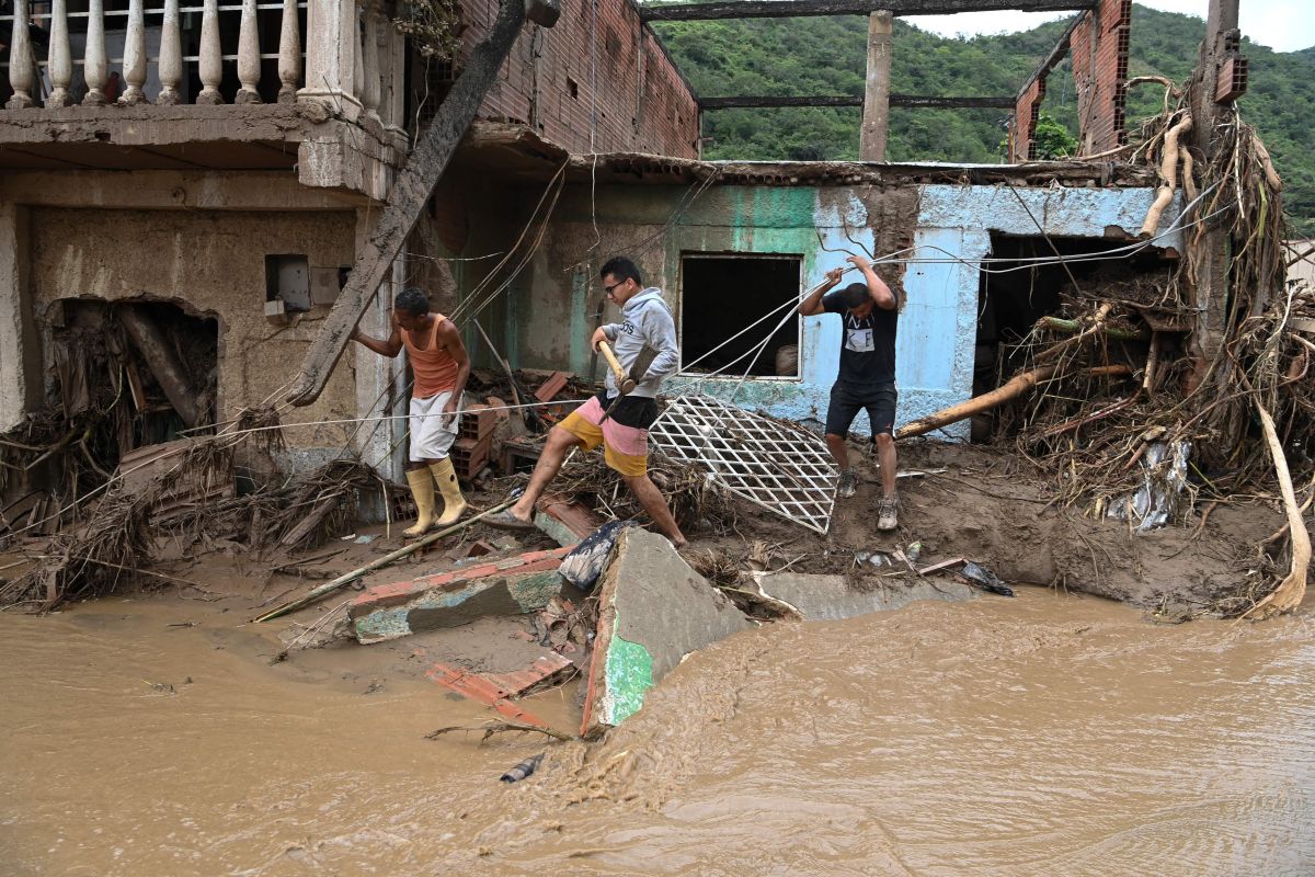 Neighbors search for victims or survivors of a landslide that destroyed dozens of homes during heavy rains in Las Tejerias, Aragua state, Venezuela, on October 9, 2022. - A landslide in central Venezuela left at least 22 people dead and more than 50 missing after heavy rains caused a river to overflow, Vice President Delcy Rodriguez said Sunday. (Photo by Yuri CORTEZ / AFP) (Photo by YURI CORTEZ/AFP via Getty Images)