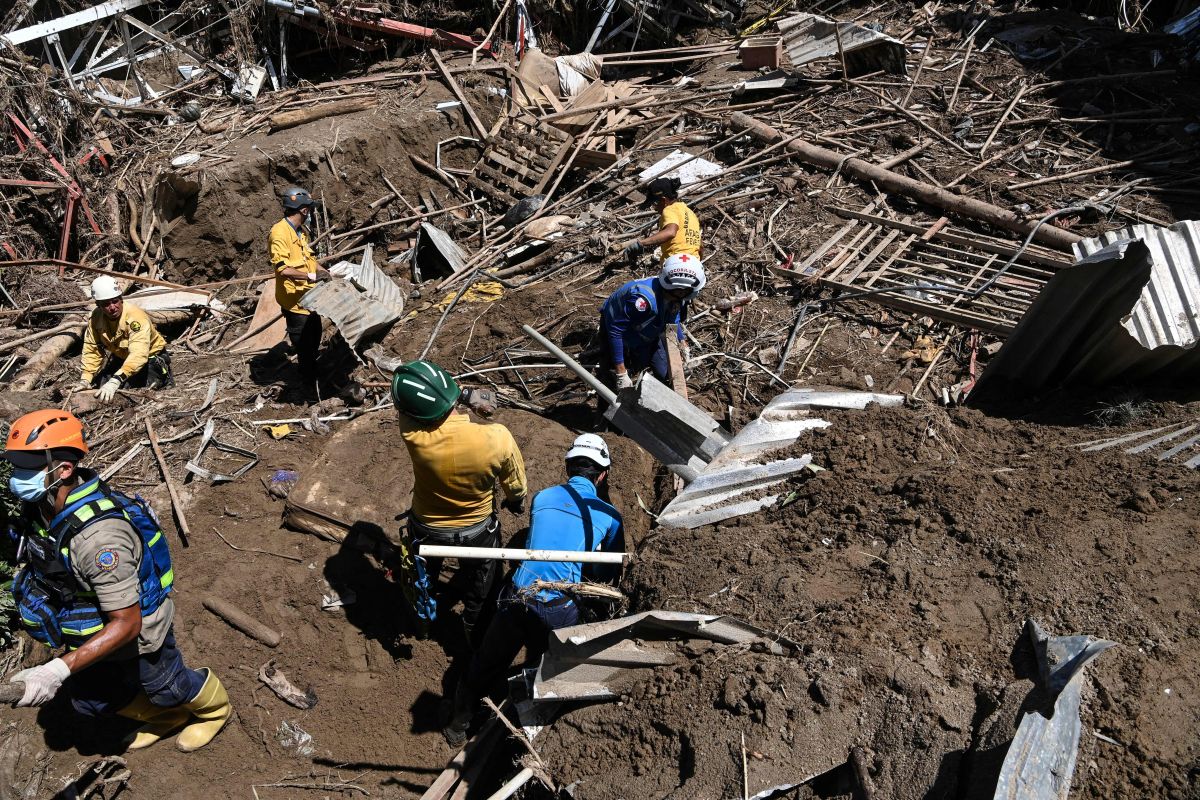 Members of a rescue team search through the rubble of destroyed houses for victims or survivors after a landslide during heavy rains in Las Tejerias, Aragua state, Venezuela, on October 10, 2022. - A landslide in central Venezuela left at least 22 people dead and more than 50 missing after heavy rains caused a river to overflow, Vice President Delcy Rodriguez said Sunday. (Photo by Yuri CORTEZ / AFP) 