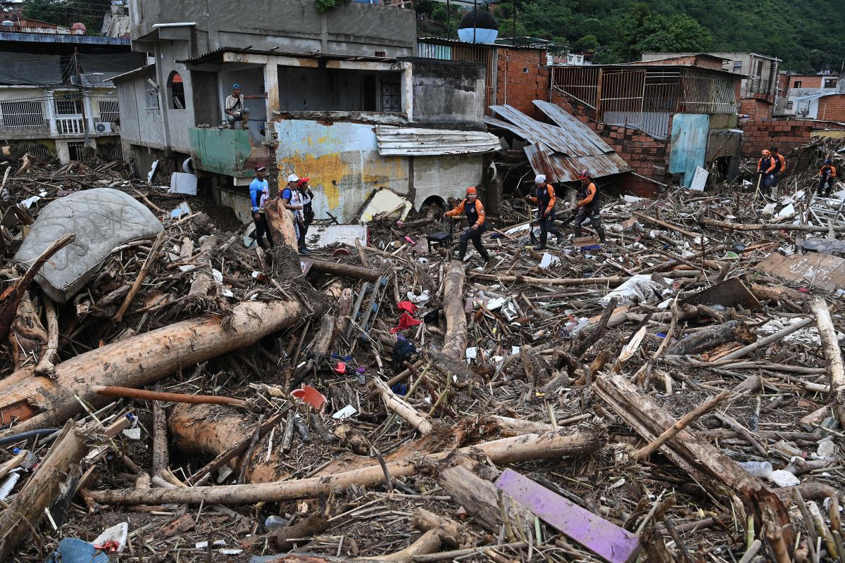 TOPSHOT - Rescuers and residents search through the rubble of destroyed houses for victims or survivors of a landslide during heavy rains in Las Tejerias, Aragua state, Venezuela, on October 9, 2022. - A landslide in central Venezuela left at least 22 people dead and more than 50 missing after heavy rains caused a river to overflow, Vice President Delcy Rodriguez said Sunday. (Photo by YURI CORTEZ / AFP) (Photo by YURI CORTEZ/AFP via Getty Images)