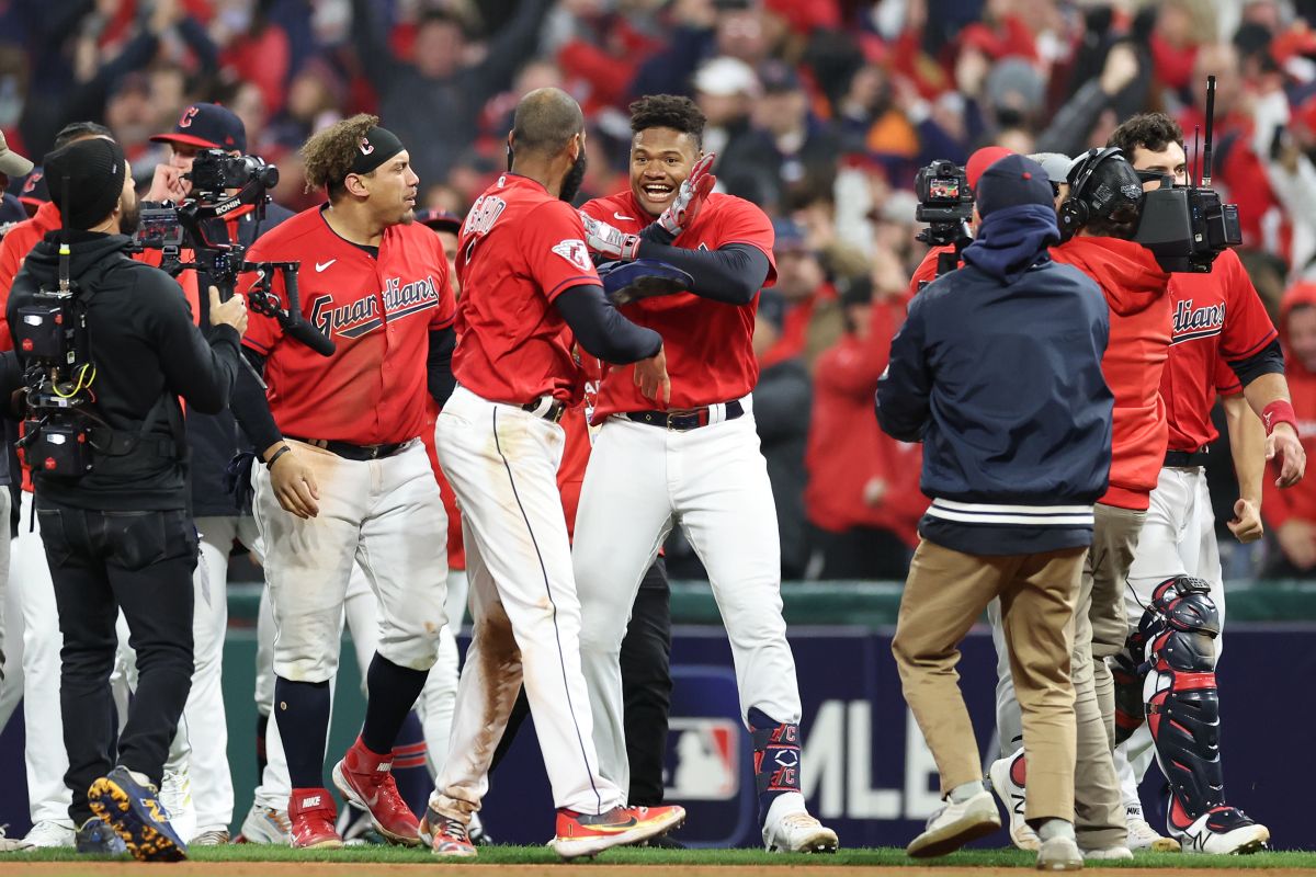 El dominicano Oscar González (C) celebra con sus compañeros tras disparar el hit que le dio la victoria en el 9no inning a Cleveland Guardians ante New York Yankees.