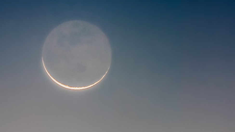 Luna creciente con la parte oscura de la Luna ligeramente iluminada por el "brillo de la tierra