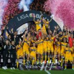 Jugadoras y cuerpo técnico de Tigres celebran con el trofeo de campeonas del Apertura 2022 de la Liga MX Femenil.