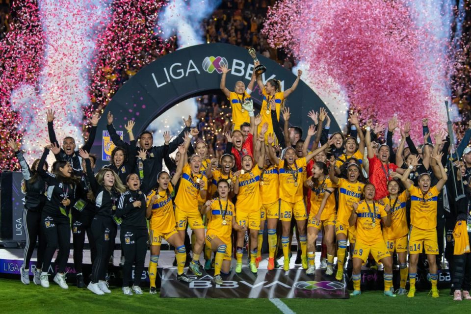 Jugadoras y cuerpo técnico de Tigres celebran con el trofeo de campeonas del Apertura 2022 de la Liga MX Femenil.