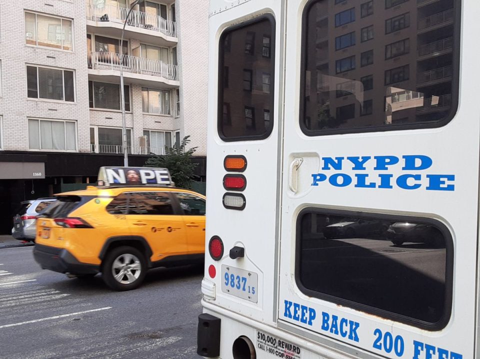 Taxi y unidad de NYPD en calle de Nueva York.