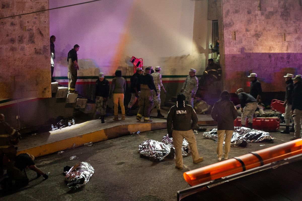 Rescatistas trabajan para sacar a heridos y cadáveres de las víctimas fuera de las instalaciones migratorias en Ciudad Juárez.