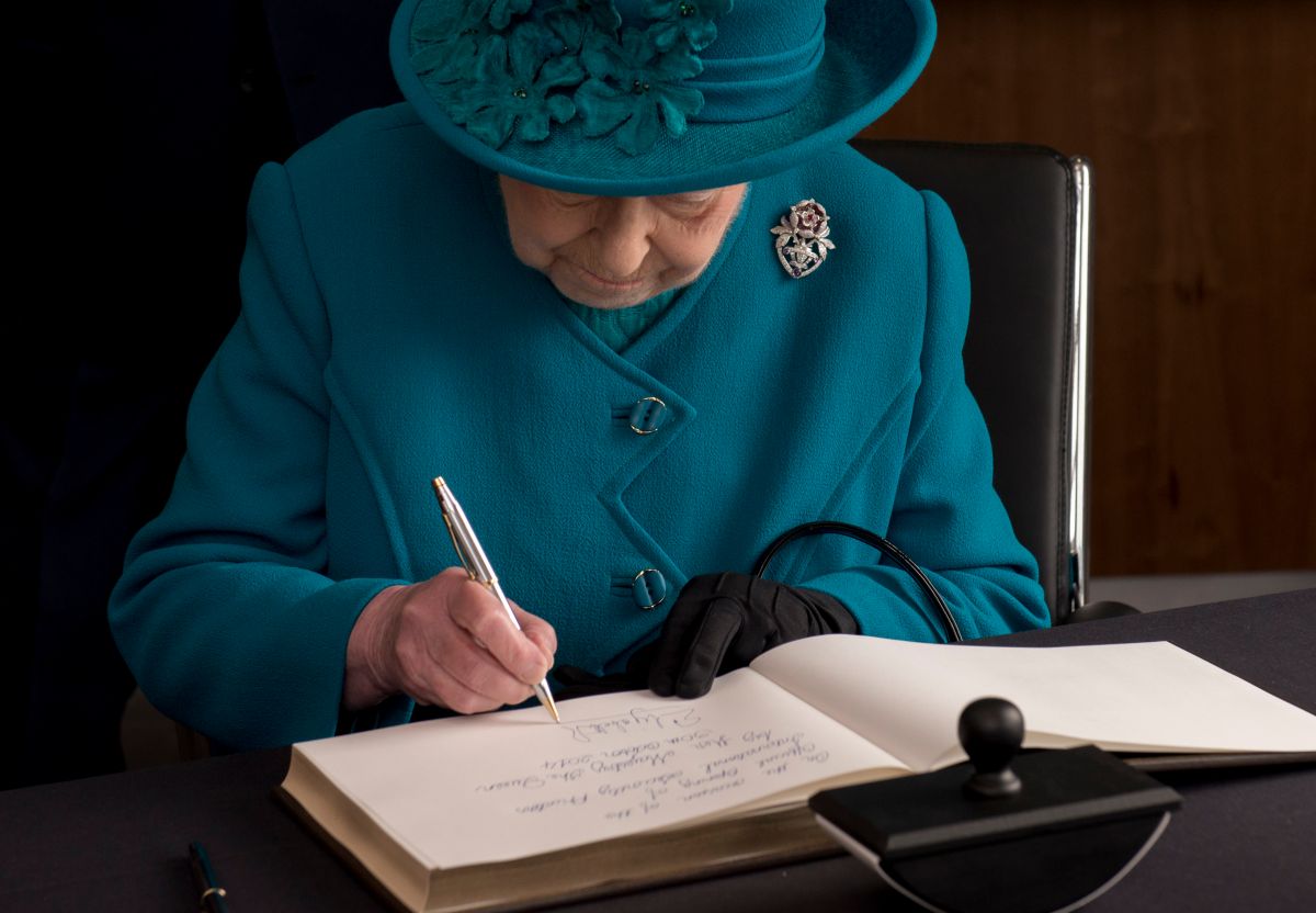 La reina Isabel II escribiendo una carta.