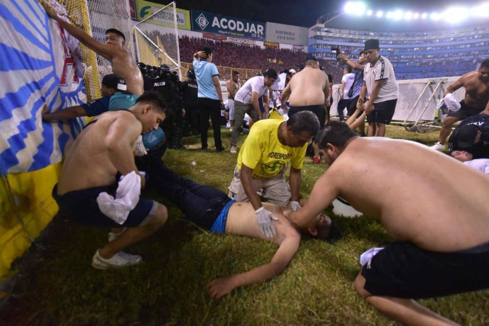 Fanáticos auxilian a personas durante una estampida en el Estadio Cuscatlán del Salvador.
